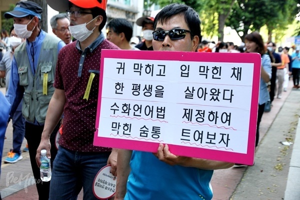 지난 2015년 '농아인의 날'에 열린 집회에서 수화언어법 제정을 촉구하는 피켓을 든 참가자.