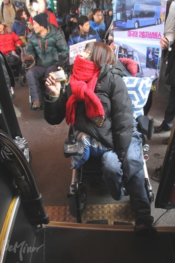 버스 표는 구매했으나 휠체어 탑승 설비가 없어 차에 오르지 못한 장애인.