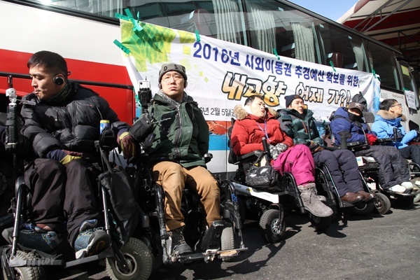 버스에 탑승하지 못한 장애인들이 항의차 버스 출발을 막고 있는 모습.
