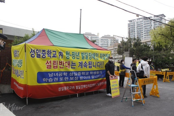 성일중학교 앞에 설치된 커리어월드 설립 반대 천막. 천막엔 “성일중학교 내 청·장년 발달장애인 직업센터 설립반대는 계속됩니다”라는 현수막이 걸려있었다.