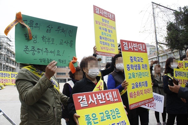 공사 반대 집회에 참여한 한 참여자가 ‘성일중학교 학부모’라는 이름으로 “교육의 삶 주체인 학생, 학부모, 교사를 존중해 주세요”라고 적힌 피켓을 들고 있다.