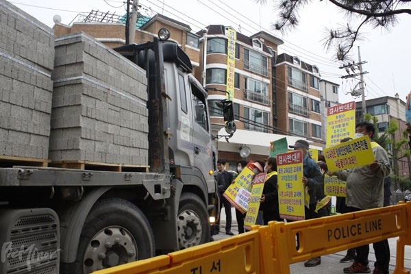 설립을 반대하는 지역주민들이 정문을 가로막아 공사 차량이 교내로 진입하지 못하고 있다