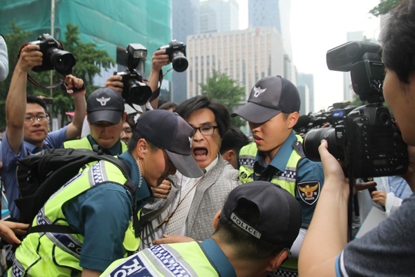 보수 기독교 단체 회원이 행진이 진행 중인 도로로 나갔다가 경찰에게 제지받는 모습.