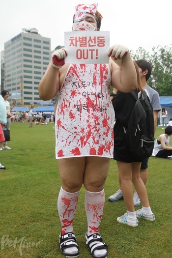 한 참가자가 동성애 전환치료의 폭력성을 묘사하는 옷을 입고 있다.