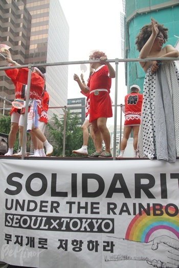 일본에서 온 도쿄 레인보우 퍼레이드 팀이 참가자들에게 손을 흔드는 모습.