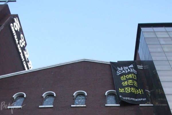 교회 건물에 "남경필 도지사는 장애인 생존권 보장하라" 현수막이 걸린 모습.