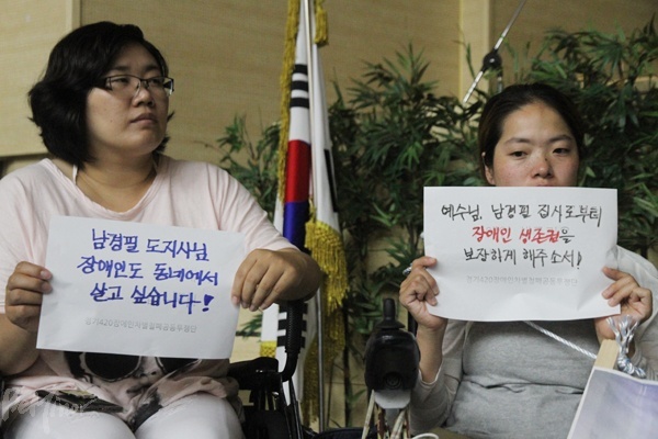 경기420공투단 회원들이 "예수님, 남경필 집사로부터 장애인 생존권을 보장하게 해주소서" 등의 피켓을 들고 있는 모습.