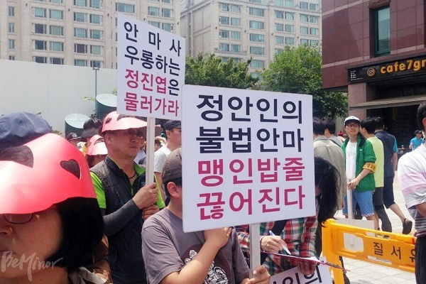 집회 참가자들이 시각장애인 안마사 생존권을 보장과 비시각장애인의 불법 안마업 규제를 요구하는 피켓을 들고 있다.