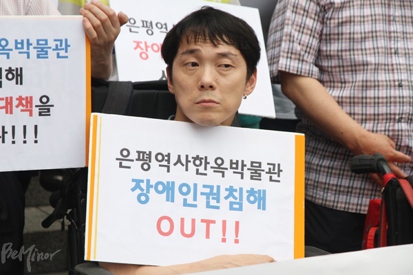 한 참가자가 "은평역사한옥박물관 장애인 인권침해 OUT"이라는 피켓을 들고 있는 모습.