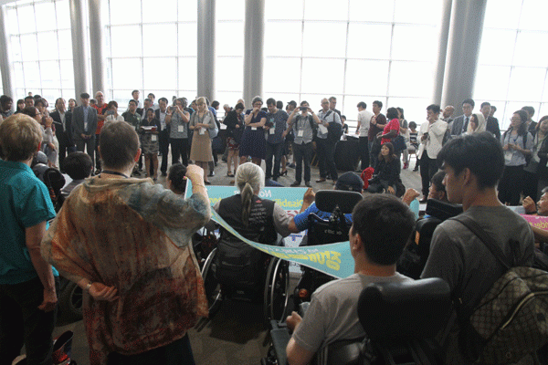 해외 참가자들이 전날 있었던 기습 시위에 대해 호기심을 표하며 기자회견을 지켜보고 있다. 