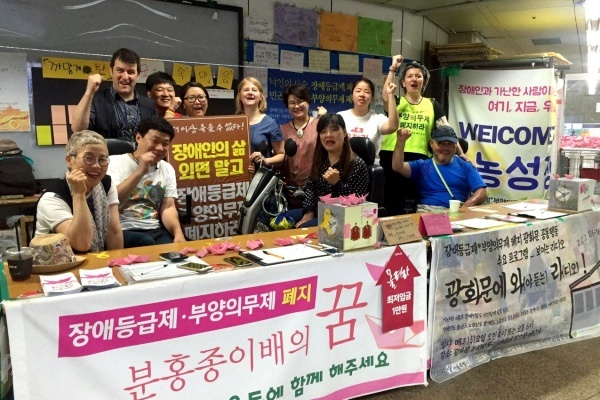 광화문공동행동 조끼와 그린라이트 조끼를 입은 레아와 가이, 그리고 루스가 한국 활동가들과 함께 광화문 농성장에서 연대를 외쳤다.