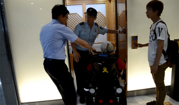 장애인단체 회원이 김관용 도지사 면담을 요구하며 자동승강기에 탑승하려고 하자 도청사 청원경찰이 이를 막고 있다. ⓒ뉴스민