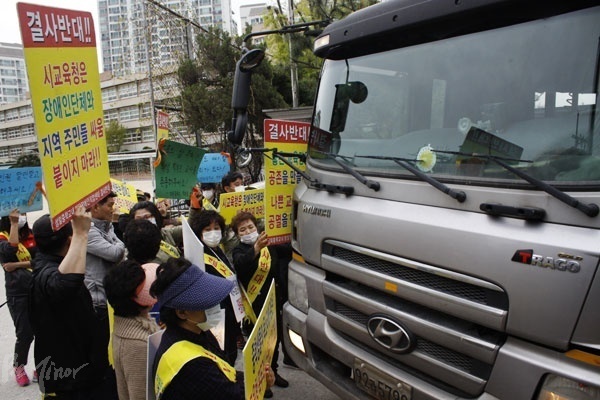 커리어월드 공사 재개날인 지난 4월 20일, 설립을 반대하는 일부 지역주민들이 모여 공사 차량 진입을 막고 있다.