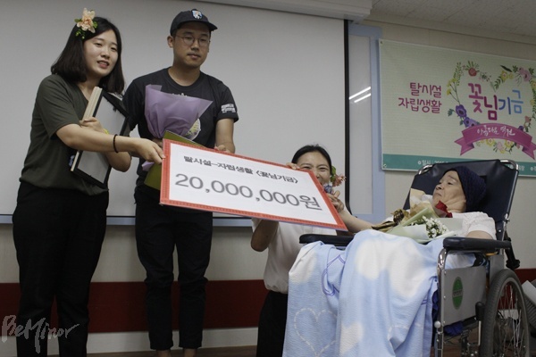 18일 노들장애인야학에서 열린 꽃님 기금 발족식에서 꽃님 씨(오른쪽)가 발바닥행동, 노들장애인야학에 2000만 원의 기금을 전달하는 모습.