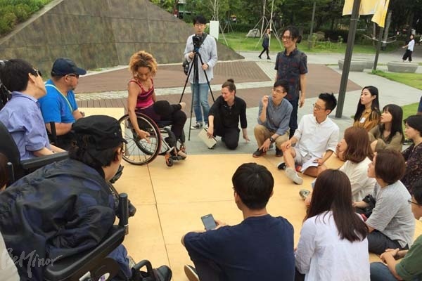 북서울시립미술관에 설치된 사라 핸드렌의 경사로 무대 위에서 앨리스 셰퍼드가 휠체어와 신체의 연결성에 관해 설명하고 있는 모습.