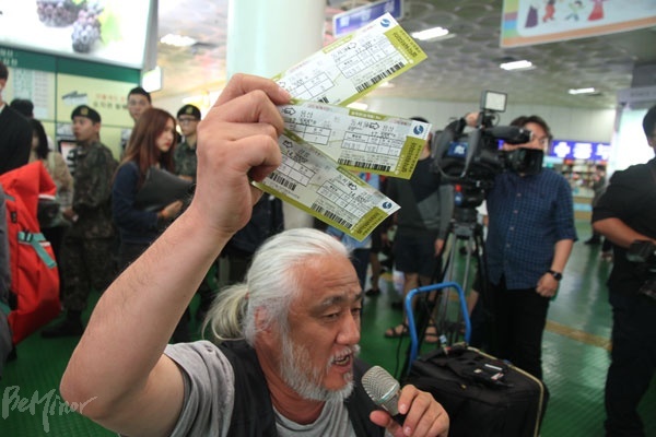 예매한 버스표를 들어 보이는 박경석 전장연 상임공동대표. 