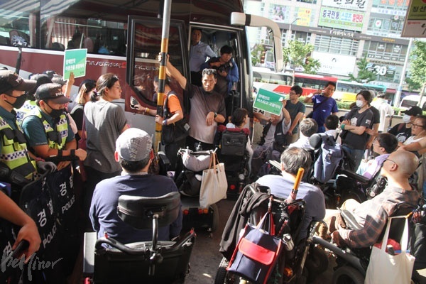 휠체어 탄 장애인은 탑승할 수 없는 버스에 대해 항의하는 장애인 활동가들.