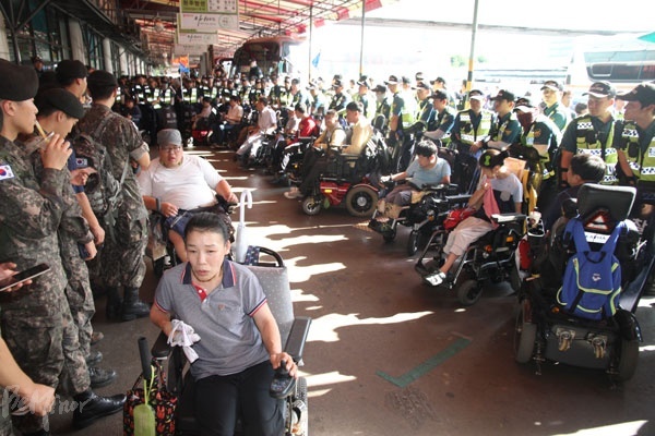 승차홈에 있는 장애인들을 에워싼 경찰들.