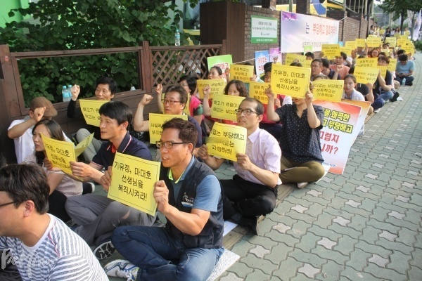 지난 7월, S 학교 앞에서 전교조 조합원들이 '부당해고 철회'를 촉구하며 집회를 하는 모습.