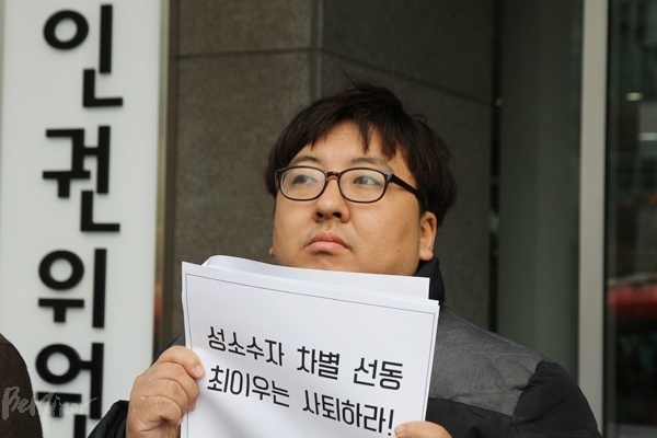 22일 시민사회가 최이우 인권위원의 사퇴를 촉구하는 기자회견을 인권위 앞에서 열었다. 기자회견 참가자가 최 인권위원 사퇴를 촉구하는 피켓을 들고 있는 모습.