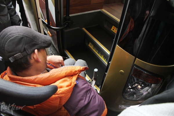 프리미엄 버스가 정식 노선에 투입된 25일 장애인들이 버스 탑승을 시도했으나, 휠체어 탑승설비가 없어 실패했다.