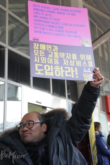한 참가자가 시외 저상버스 도입을 촉구하는 피켓을 들고 있는 모습.