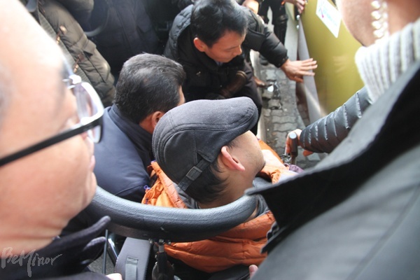 터미널 직원과 경찰이 버스에 타려던 장애인을 끌어내는 모습.