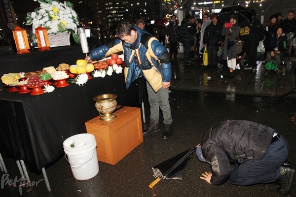한 참가자가 무명 홈리스들을 추모하며 절하고 있다.