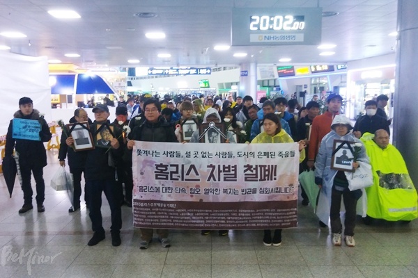 참가자들이 서울역 역사를 행진하며 홈리스 강제 퇴거에 항의하고 있다.