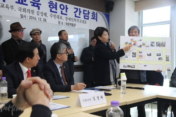 특수학교 설립 반대 비대위 수석부위원장이라고 밝힌 전아무개 씨가 강서구는 한방의학특구가 되어야 한다며 준비한 지도를 통해 이영 교육부 차관에게 지역 특성을 설명하고 있다.