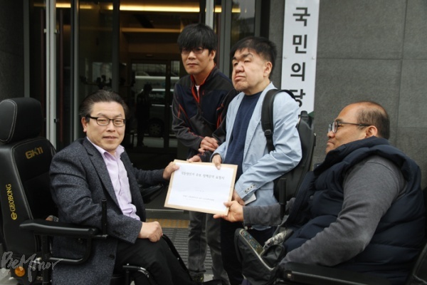 장애인문화공대위의 요구안을 받은 정중규 국민의당 장애인위원장(왼쪽).