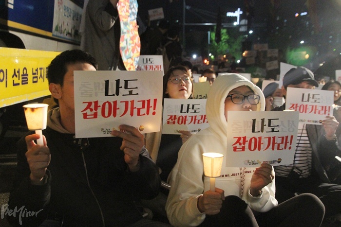 성소수자 당사자들과 시민들이 육군의 동성애자 군인 색출, 처벌에 항의하고자 21일 국방부 앞에서 열린 촛불집회에 참여한 모습. 참가자들이 '나도 잡아가라'는 피켓을 들고 있다.