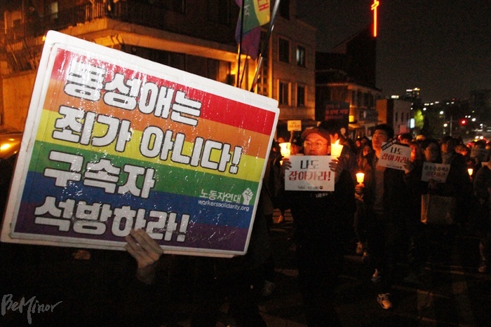 참가자들이 피켓과 촛불을 들고 행진하는 모습.