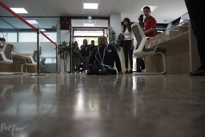 이정훈 전국장애인차별철폐연대 정책실장이 휠체어에서 내려 1층 바닥을 기어가고 있다.  