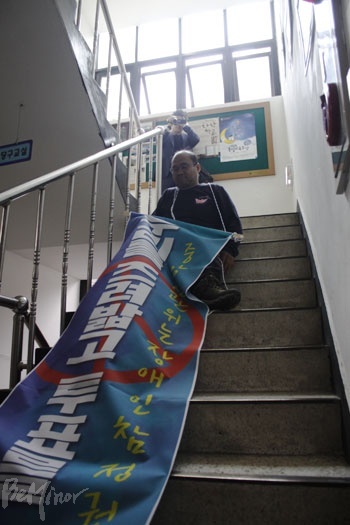 삼청동 주민센터는 투표소가 2층에 있음에도 엘리베이터가 설치되어 있지 않다. 2층 투표소로 가는 계단을 기어 올라가는 이정훈 전국장애인차별철폐연대 정책실장