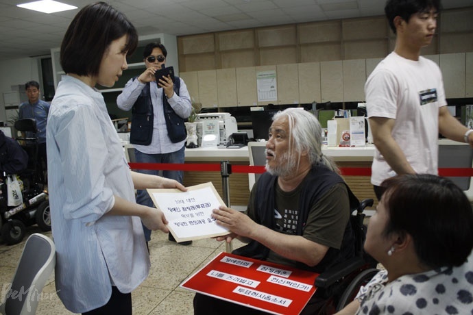 사전투표를 마치고 나온 박경석 대표가 중앙선관위 측 관계자에게 요구서를 전달하고 있다. 