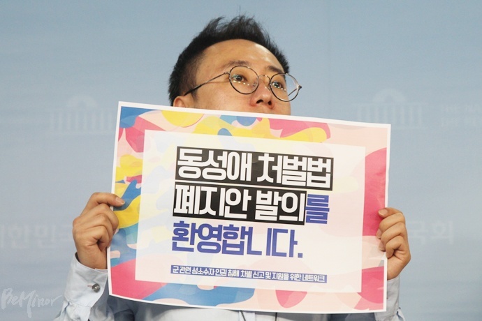 한가람 변호사가 25일 국회 정론관에서 열린 군형법 92조의6 폐지안 발의 기자회견에 참가해 법안 발의를 환영하는 피켓을 들고 있다.