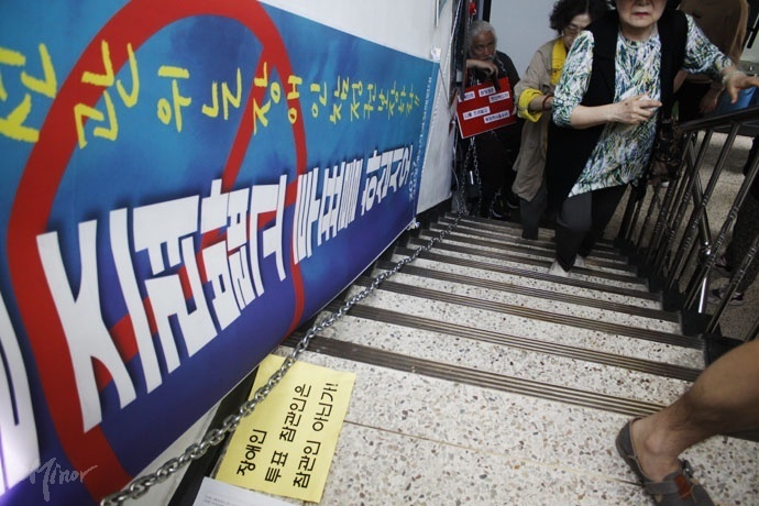 19대 대선 사전 투표 기간에 휠체어로 올라갈 수 없는 2층 이상 건물에 사전 투표소를 설치한 것에 대해 장애인들이 항의한 모습.