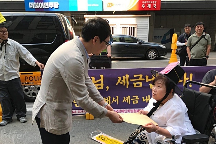 박김영희 장추련 대표가 더민주당 민생지원국 직원에게 요구안을 전달하고 있다.