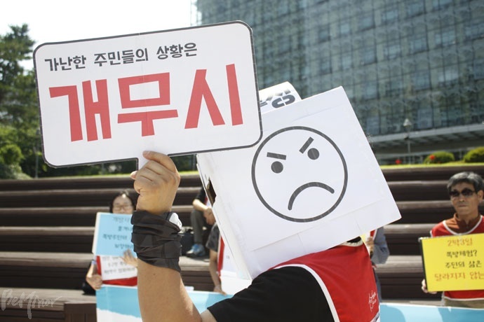 홈리스행동 활동가가 가난한 이들의 상황은 정작 무시한 채, 다정한 얼굴로 빈곤을 전시하며 대학생을 맞이하는 ‘중구청의 두 얼굴’에 대한 퍼포먼스를 하고 있다. 