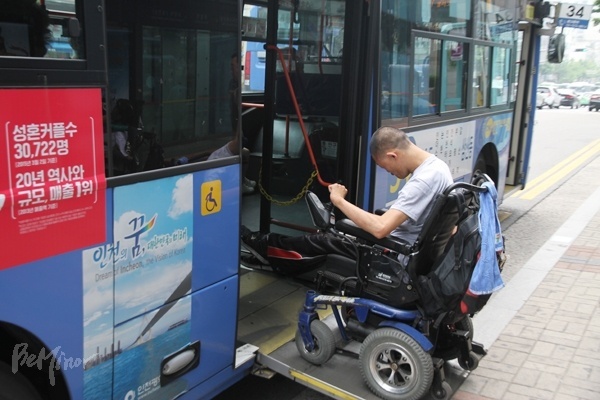 휠체어를 탄 장애인이 저상버스에 탑승하는 모습. 사진은 이번 사건과 무관하다.
