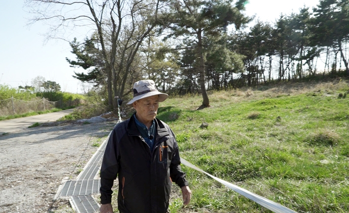 김춘근 씨가 선감학원 원생들이 묻혀 있는 우물재산을 둘러보고 있다.