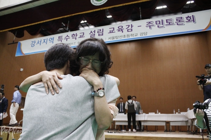 강서구 특수학교 설립 주민토론회에서 주민들의 거센 반대의 목소리가 나오자 장애부모들이 서로를 부둥켜 안고 울고 있다.