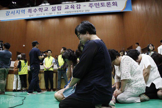 지난 9월 5일 탑산초등학교에서 열린 강서구 특수학교 설립 교육감-주민 토론회. 장애학생부모들이 무릎을 꿇고 특수학교 설립을 호소하고 있다.