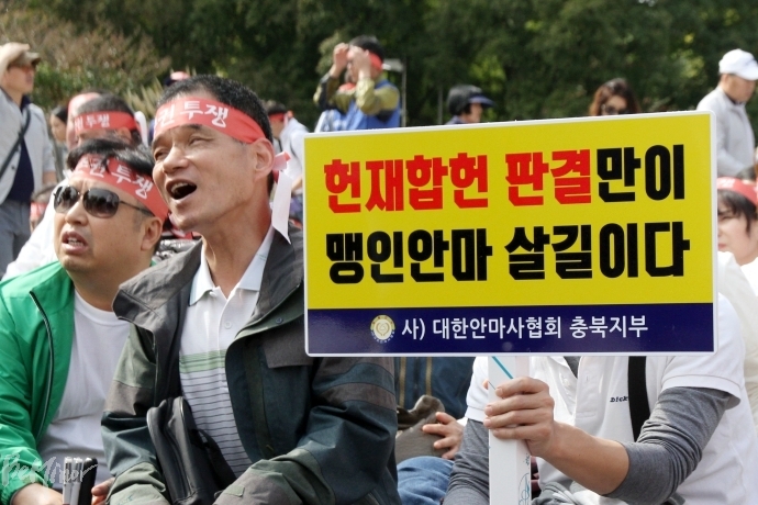 16일 대한안마사협회가 주최한 총궐기대회에서 "헌재 합헌 판결만이 맹인 안마 살길이다" 피켓을 들고 있는 시각장애인 안마사들.