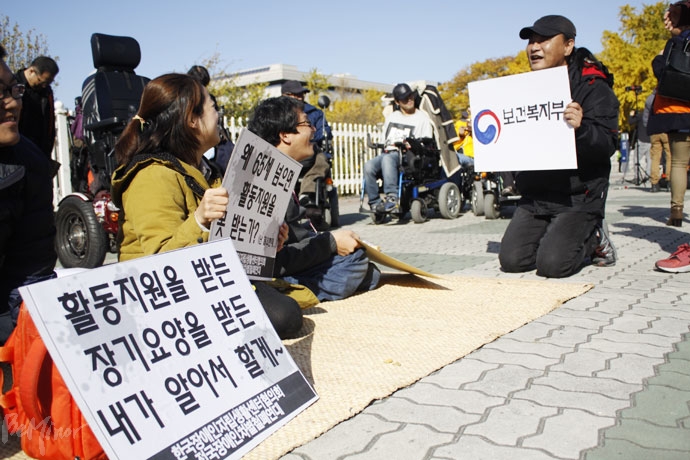 전국장애인차별철폐연대와 한국장애인자립생활센터협의회는 8일 국회 앞에서 기자회견을 열고 ‘65세 연령 제한’을 삭제하라며 ‘장애인활동지원에 관한 법’ 개정을 국회에 요구했다. 기자회견 후, 활동지원 65세 연령 제한을 풍자하는 퍼포먼스를 하는 활동가들.  