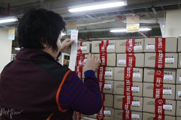 김정선 씨가 바코드 종이를 붙이고 있다. 김정선 씨가 바코드 종이를 붙이고 있다.