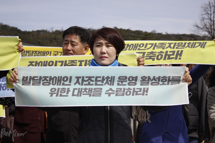 한 참가자가 '발달장애인 자조단체 운영 활성화를 위한 대책을 수립하라'는 내용의 피켓을 들고 있다