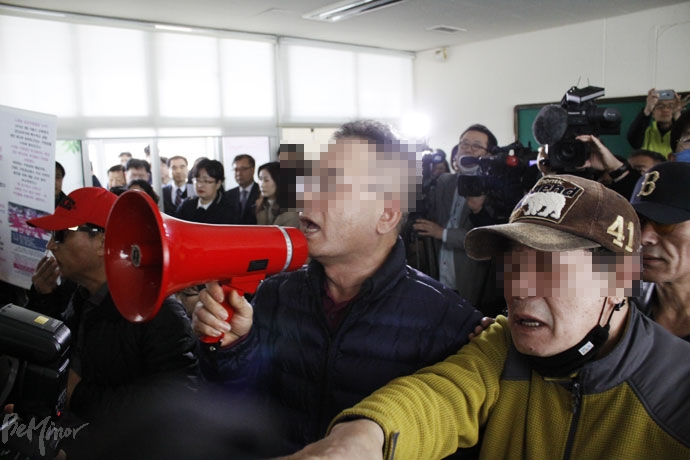 특수학교 설립을 반대하는 주민이 확성기를 이용해 설명회 진행을 방해하고 있다. 