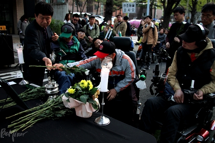 추모제 참석자들이 고인의 영정 앞에 헌화하고 있다.